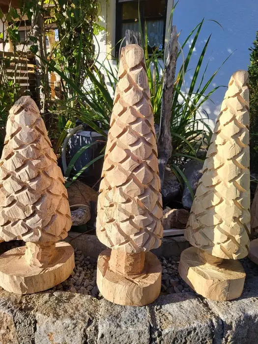 Drei geschnitzte Zapfen aus Holz auf Sockeln