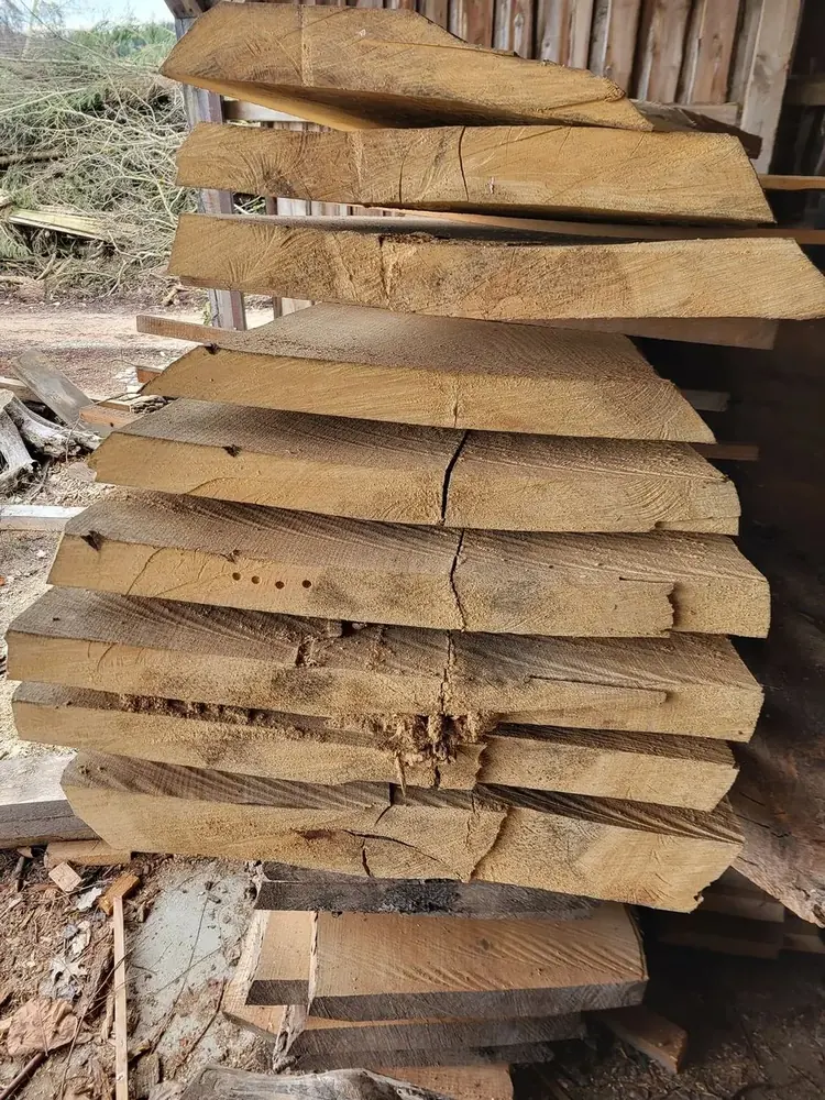 Stapel frisch geschnittener Holzbohlen unterschiedlicher Stärke