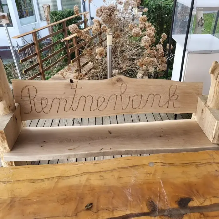 Holzbank mit eingeschnitztem Schriftzug Rentnerbank