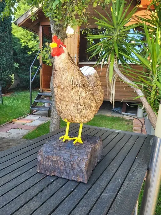 Bemalter Hahn aus Holz auf einem Holzsockel